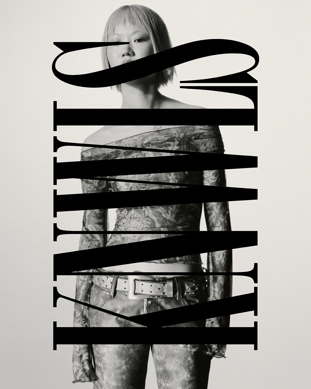 Monochrome portrait of a person with short hair wearing an off-the-shoulder top and jeans. Graphic text overlays the subject.
