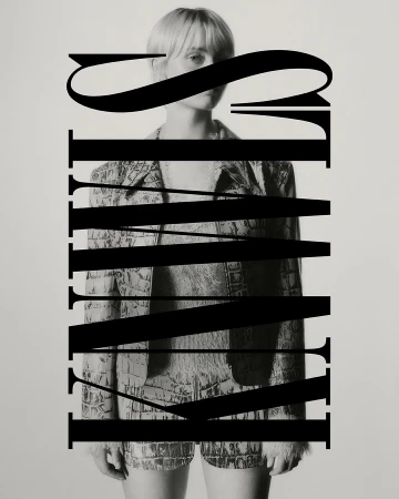 Monochrome portrait of a blonde woman in a patterned suit, partly obscured by bold typographic elements, creating a stylish editorial image.