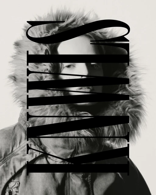 Monochrome portrait of a person wearing a hooded winter coat, with large black text overlaying the center of the image.