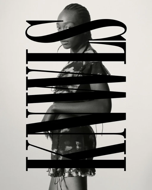 Portrait of a woman in a dress, partially obscured by bold black typography, against a plain off-white background, medium framing.