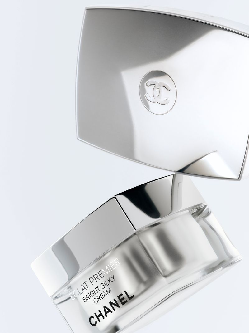 Chanel skincare product is displayed with a mirrored cosmetic compact on a clean, white background in a beauty still life shot.