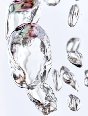 Close-up macro view of transparent liquid water bubbles rising against a bright white background.