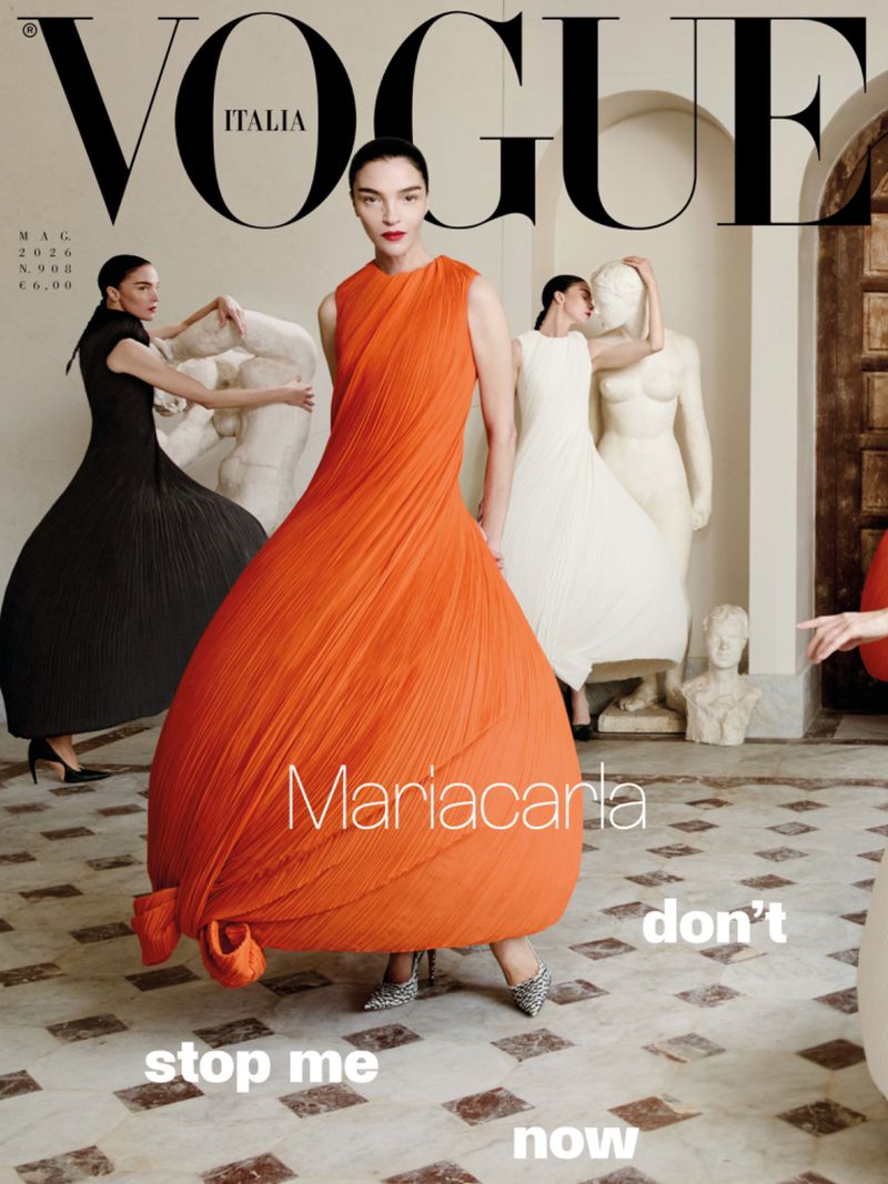 Vogue Italia magazine cover featuring a model in an orange dress, with models in white and black dresses and white sculptures in the background.