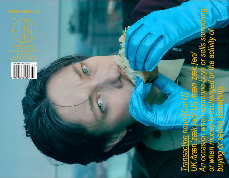 Model wearing bright blue leather gloves eating a sandwich on the cover of Double Magazine issue 51.