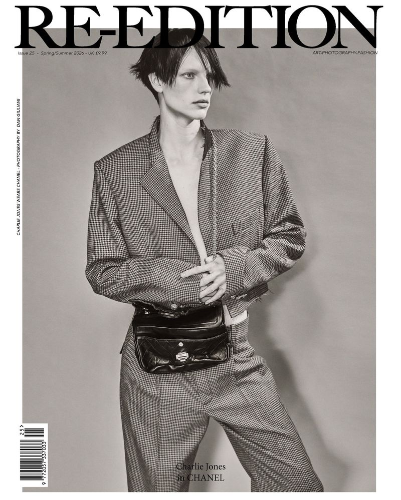 Fashion editorial magazine cover featuring a person in a suit with a fanny pack posing against a neutral background.