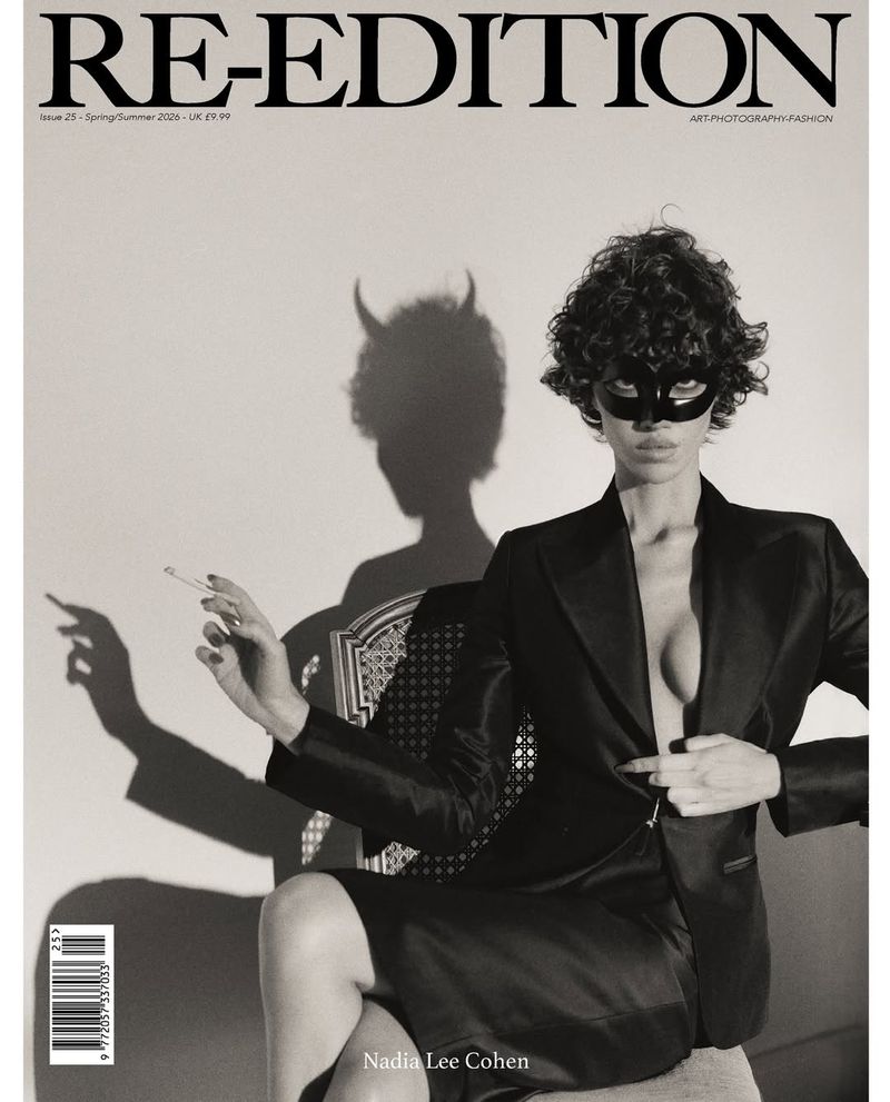 Black-and-white fashion magazine cover featuring a model in a black suit, mask, and the magazine's title, RE-EDITION, prominently displayed.
