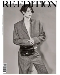 Model Charlie Jones poses in a houndstooth suit with a black Chanel waist bag for the Re-Edition Magazine cover.