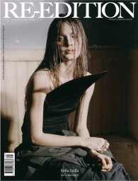 Sofia Isella wearing a sculptural black top and dark skirt with wet hair in a magazine cover editorial portrait.
