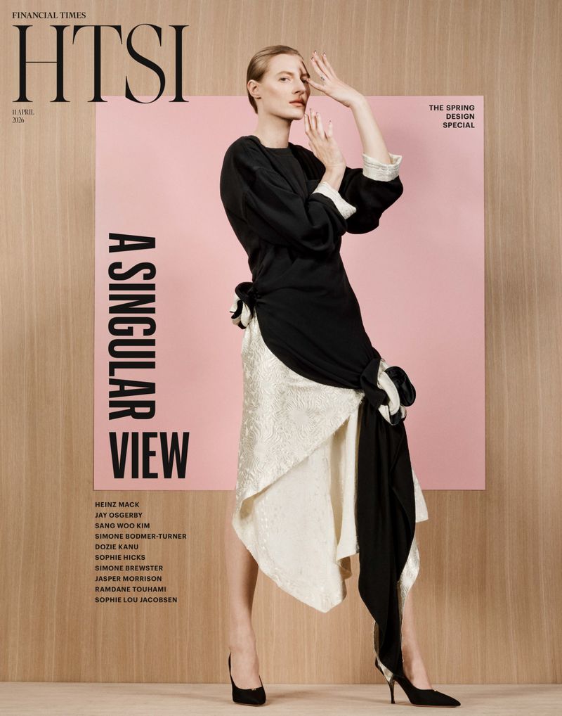 Fashion editorial cover featuring a posing fair-skinned woman in black and white asymmetrical dress, dark heels against a pastel background.
