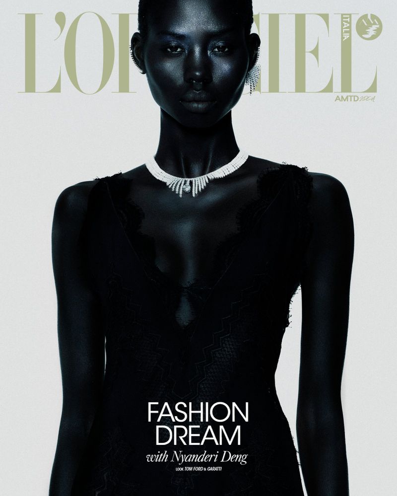 Fashion magazine cover featuring a woman with dark skin wearing a black dress and diamond necklace, in a close-up studio shot.