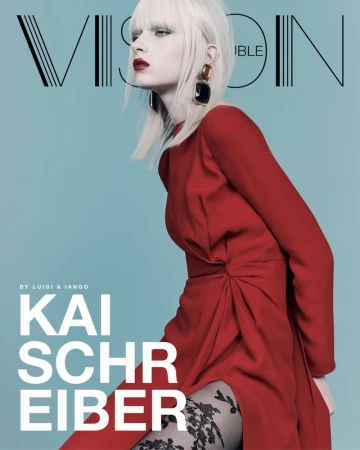 Magazine cover featuring a blond fashion model in a long-sleeved red dress and lace tights against a light blue background.