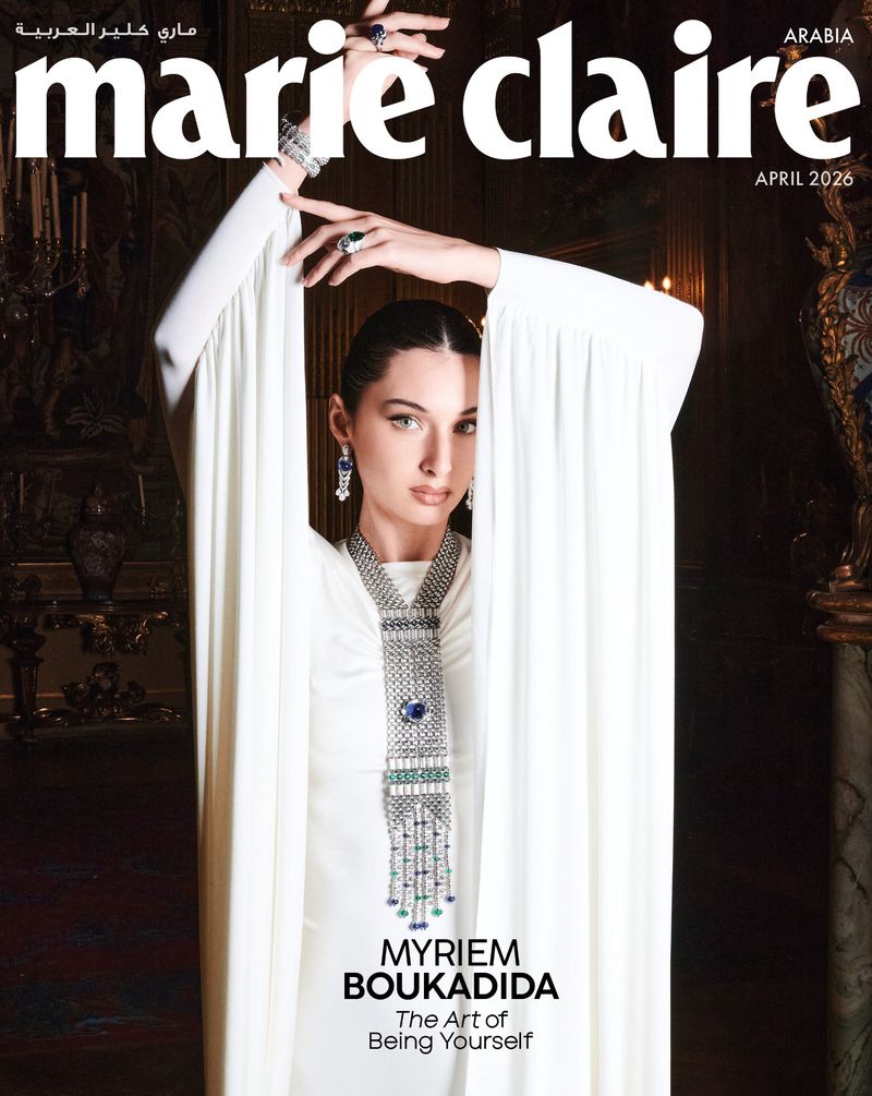 Marie Claire Arabia cover featuring Myriem Boukadida in a white dress and jewelry. Dark interior background. Magazine cover.