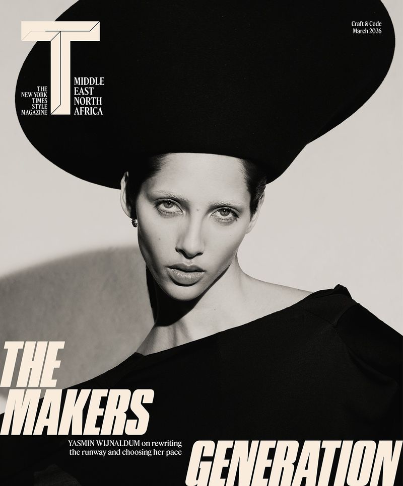 Model Yasmin Wijnaldum in an oversized black sculptural hat and black top for a monochrome editorial portrait.