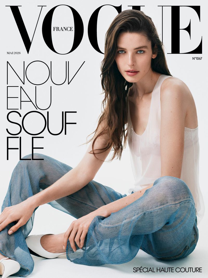Vogue France cover featuring a woman with long hair, wearing a white top and blue pants, sitting against a white background.