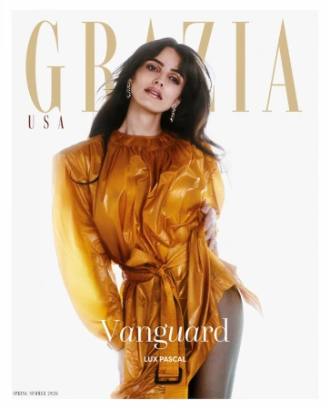 Fashion magazine cover featuring a woman with dark hair wearing a shiny golden dress, set against a bright white backdrop with brand and title.