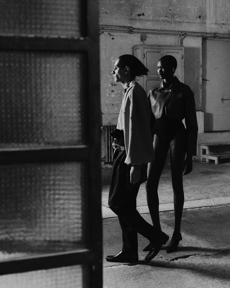 Two models walking through an industrial interior shot in monochrome film grain by photographer José Cuevas.