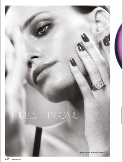 Close-up portrait of a woman with dark nail polish and diamond ring; black-and-white image for beauty or fashion advertising.