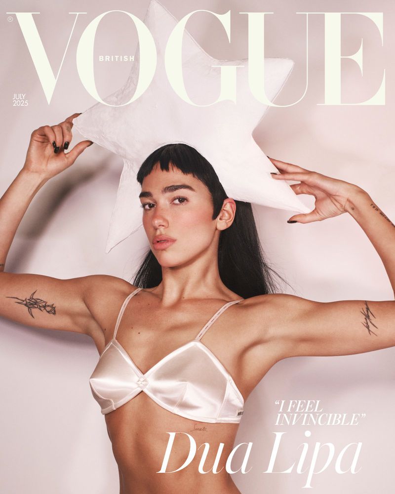 Dua Lipa on British Vogue cover. She poses with a white star hat and light pink lingerie, set against a clean background with brand text.