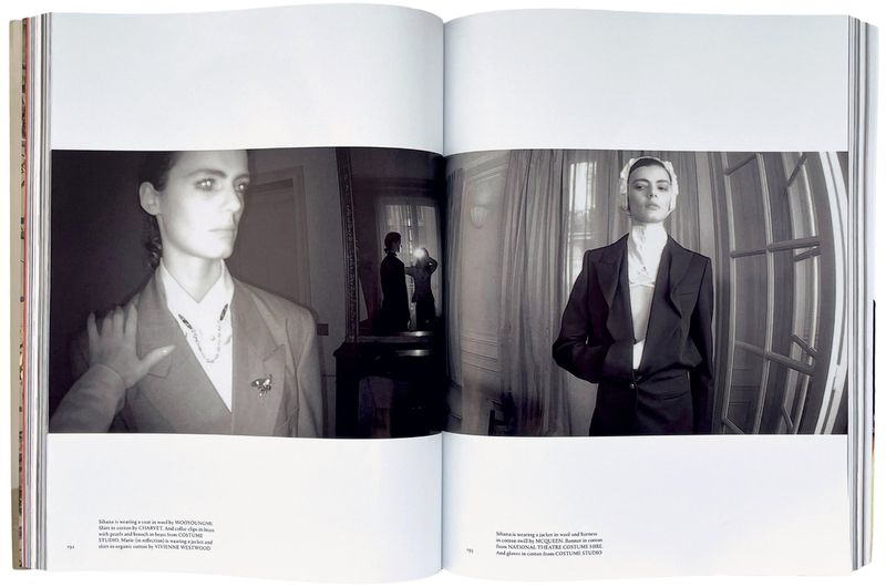 Black and white fashion editorial in a book, featuring two models wearing tailored suits in interior settings with natural light.