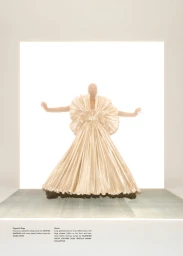 Model wearing a voluminous pleated metallic dress standing against a bright backlit background in SS 2026 for SSAW Magazine