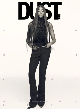 Magazine cover featuring a full-length shot of a fashion model in black pants and a feather top against a neutral gradient background.