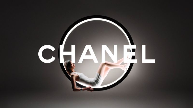A stylish advertising visual featuring an adult female reclining within a luminous circle, with the word CHANEL prominently displayed.