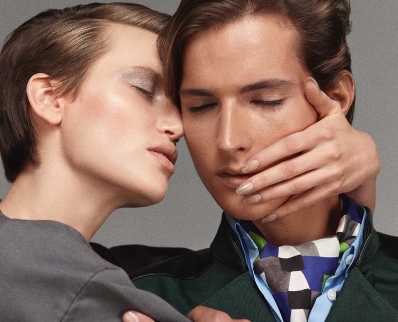 Close-up studio shot of a stylish young adult couple with closed eyes, showcasing fashion-forward clothing, accessories, and soft lighting.