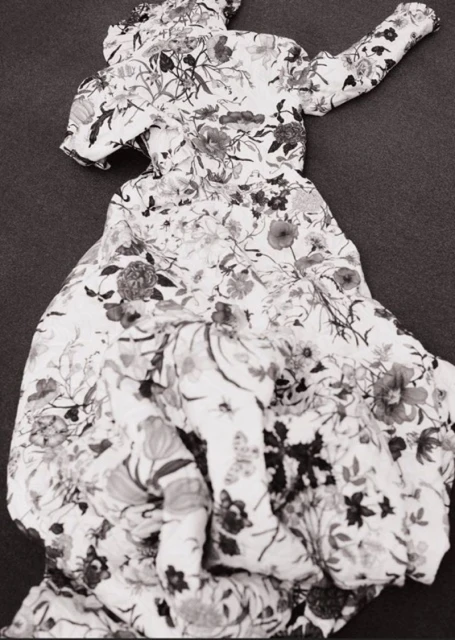Floral-patterned dress on a flat surface. Monochrome image showcases the garment's fabric and design. Ideal for fashion or textile collections.