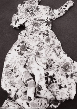 Floral-patterned dress on a flat surface. Monochrome image showcases the garment's fabric and design. Ideal for fashion or textile collections.