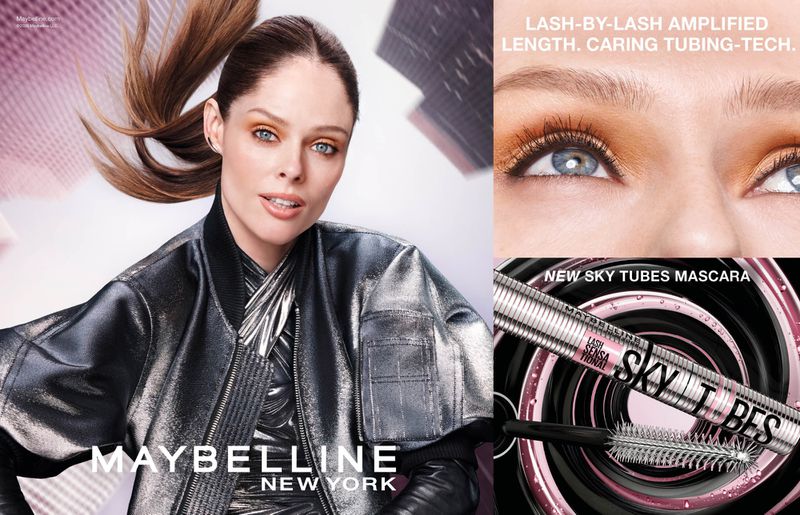 Beauty shot featuring a woman with a metallic jacket. The image also displays mascara product packaging. Focus on cosmetics advertising.