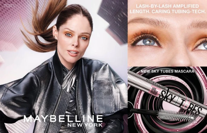 Beauty shot featuring a woman with a metallic jacket. The image also displays mascara product packaging. Focus on cosmetics advertising.