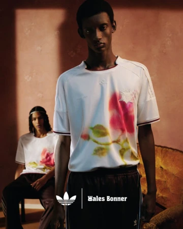 Two dark-skinned adult men model Adidas x Wales Bonner floral-print soccer jersey and track pants against neutral background.