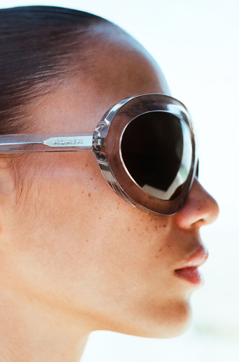 A close-up studio shot of a fair-skinned adult female wearing oversized sunglasses, showcasing beauty and fashion eyewear.