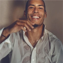 Virgil van Dijk smiling broadly in a wet white button-up shirt in a studio portrait for Fantastic Man.