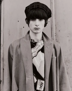 Monochrome portrait of a young male model wearing a patterned beret and tailored coat for Fucking Young Inferno Kids editorial.