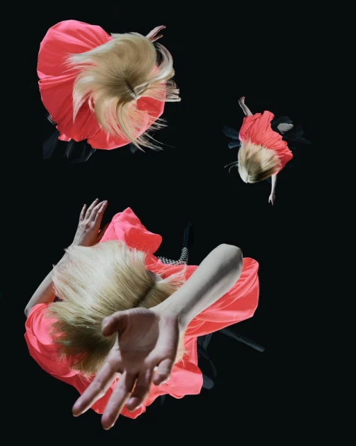 Overhead shot of three adult females in bright pink dresses against a black background, blonde hair visible, one figure with outstretched hand.