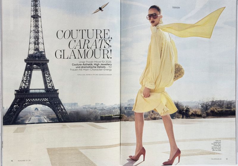Fashion editorial featuring a woman walking near the Eiffel Tower in Paris, wearing a yellow dress, scarf, and sunglasses for a couture look.