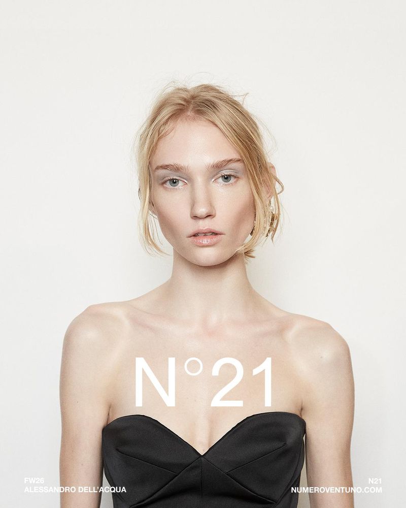 A model poses indoors wearing a black strapless top, with the brand "N°21" superimposed on the image in white letters against a white background.