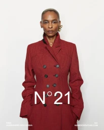 Model with short buzzcut wearing a tailored double-breasted red check coat against a neutral background with N21 branding.