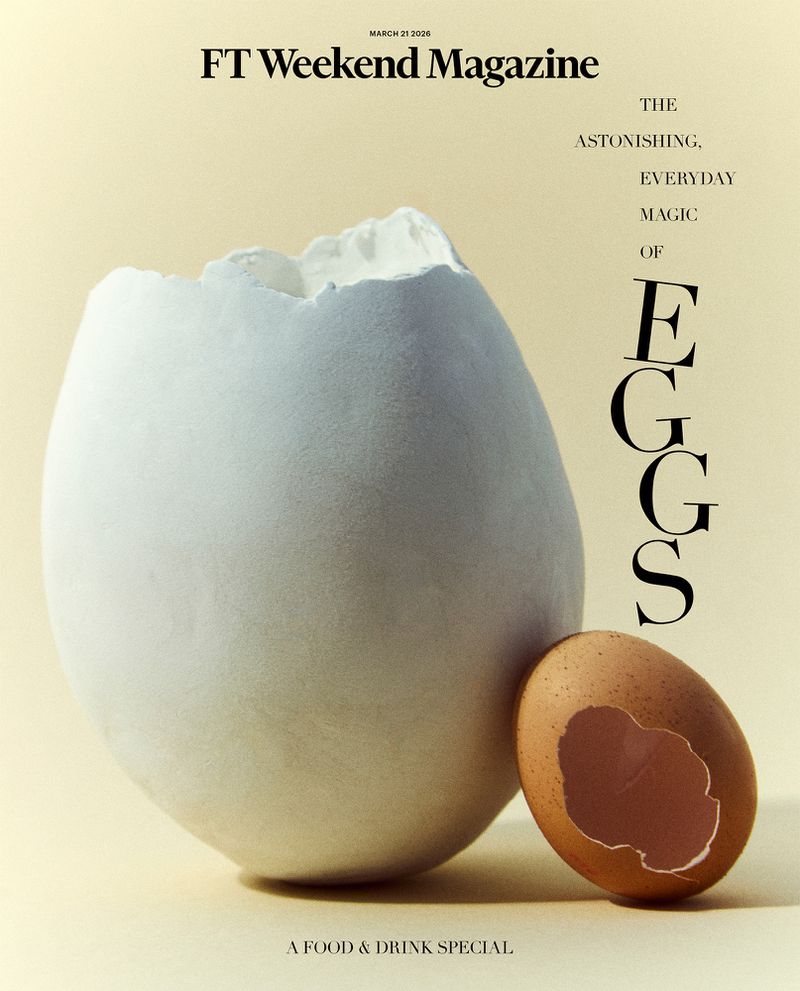 Broken white egg beside a brown egg on a beige background with a magazine cover featuring the word 'eggs'. Food photography.