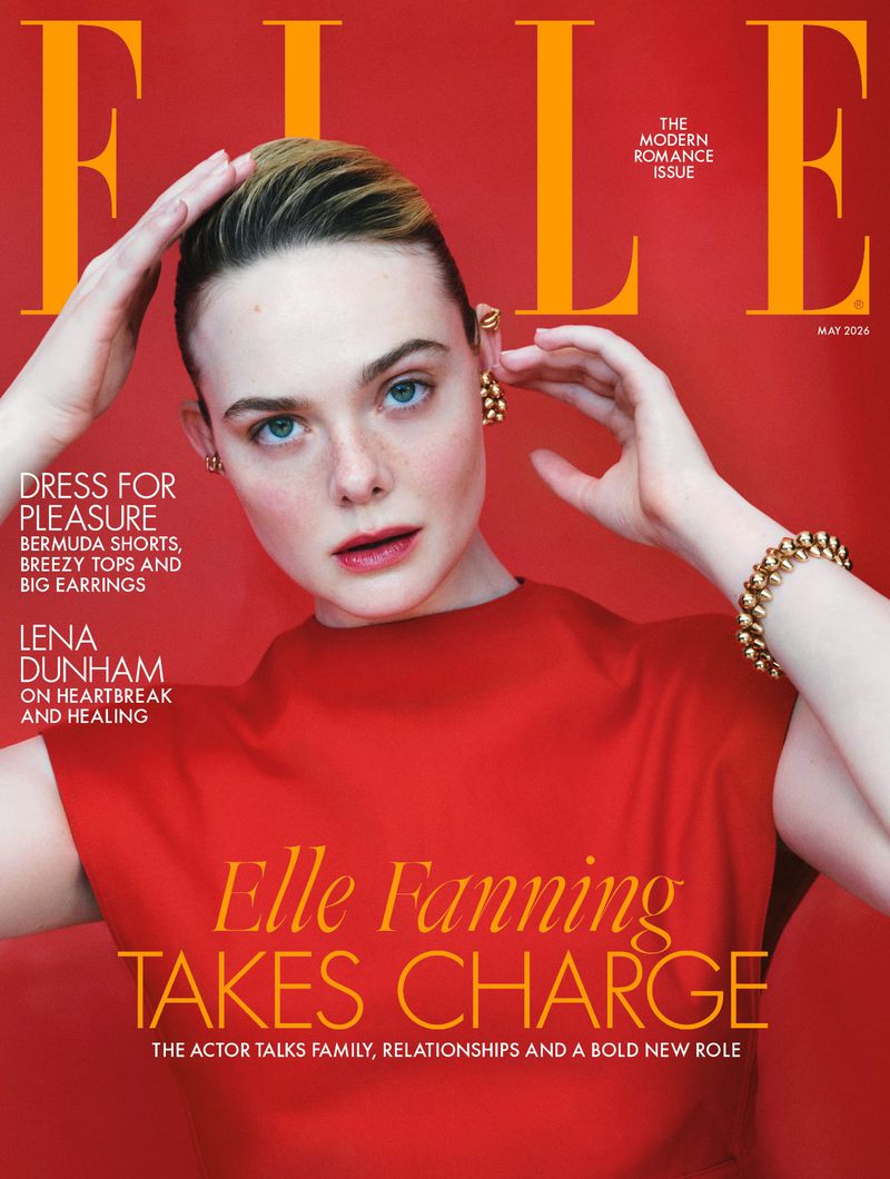 Elle Fanning, on the cover of Elle Magazine, poses in red dress with gold earrings and bracelet against a vibrant red background.