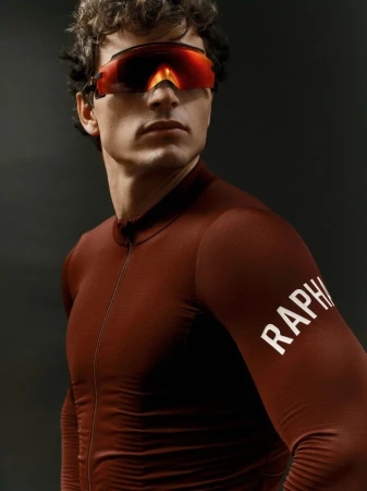 Man in cycling jersey and sunglasses. Close-up studio shot highlighting sportswear and athletic fashion against a dark background.
