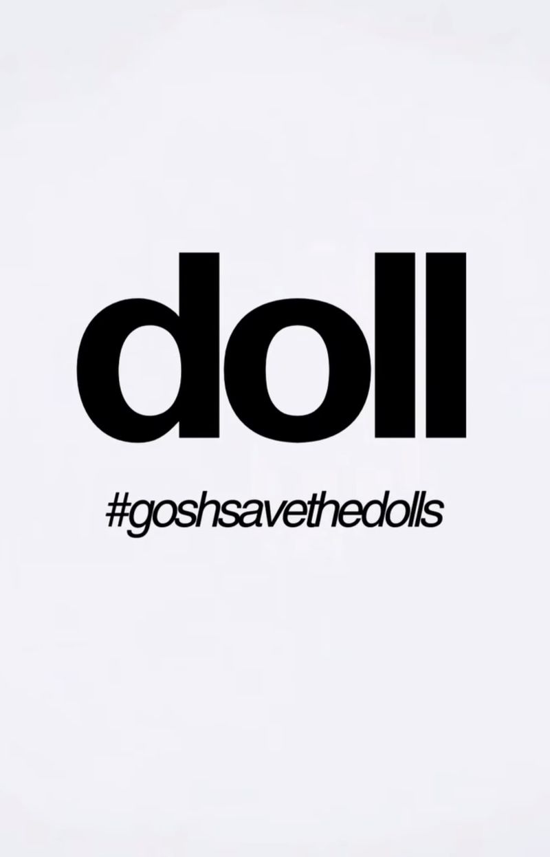 Graphic design with bold black 'doll' typography above a hashtag, #goshsavethedolls, on a clean white background.