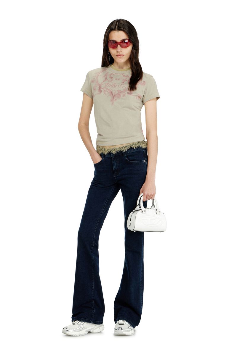 Adult female fashion model posing in studio wearing a beige t-shirt, blue denim jeans, white sneakers, and red sunglasses with a white bag.