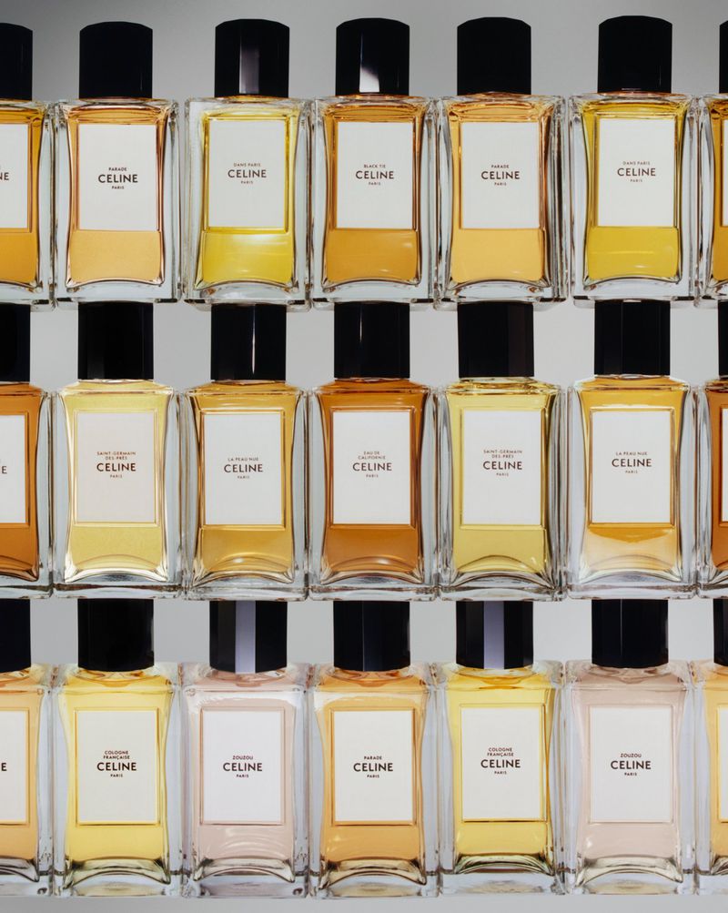 Array of Celine perfume bottles in clear glass with black caps arranged on shelves, showcasing a beauty and fashion product display.