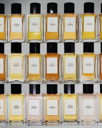 Array of Celine perfume bottles in clear glass with black caps arranged on shelves, showcasing a beauty and fashion product display.