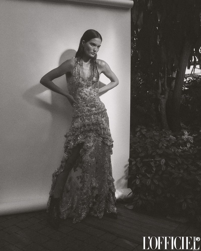 Monochrome fashion shot of a woman in an embellished, sleeveless dress posing against a wall in a studio and outdoor setting.