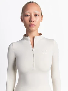 Dechen Grenfell posing in a cream zip-up top from The North Face Skims Winter Collection against a seamless white studio background.