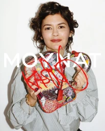 Audrey Tautou holding an illustrated Moynat handbag against a white background.