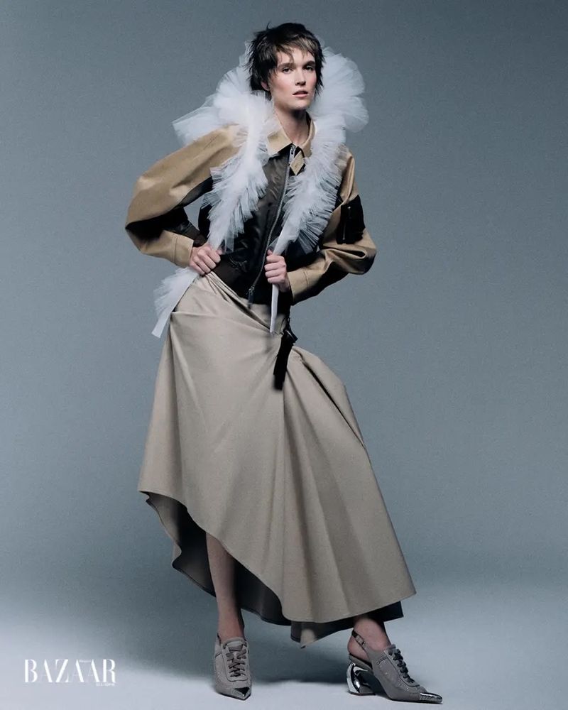 Fashion model in a beige structured skirt, black vest, and white tulle ruffle collar for Harper's Bazaar Ecuador.